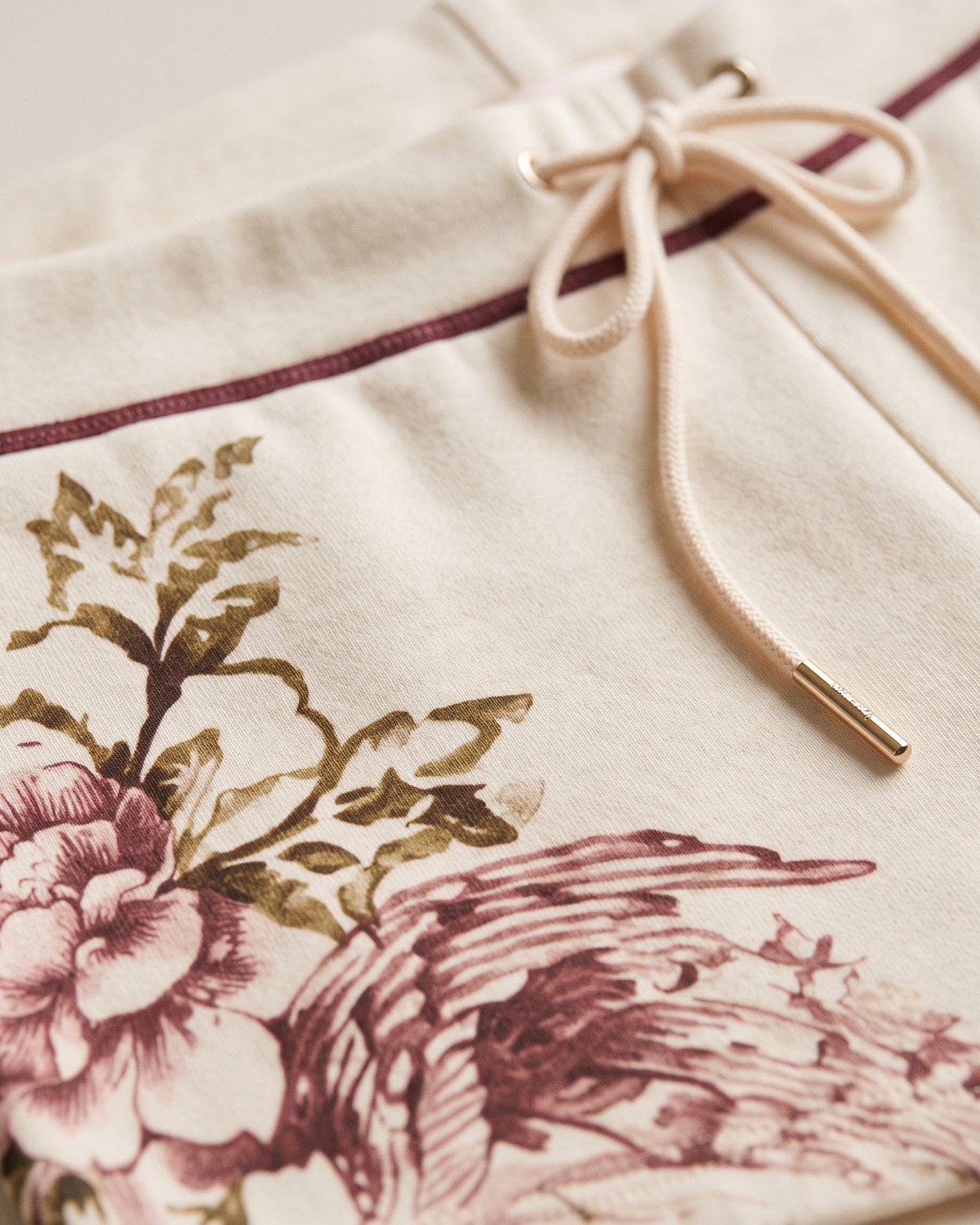 Macro Close-Up of the botanical print and burgundy tipped drawcord on Rosie Cove Low-Rise Shorts